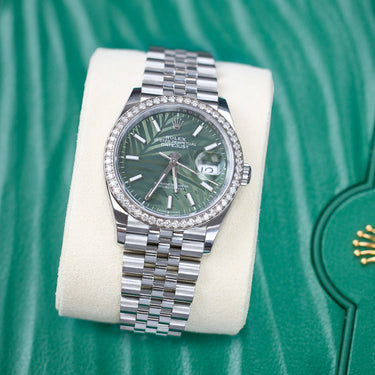 Rolex Datejust with a diamond bezel and green palm motif dial and jubilee bracelet. Stainless steel. Shown against Green Rolex box.